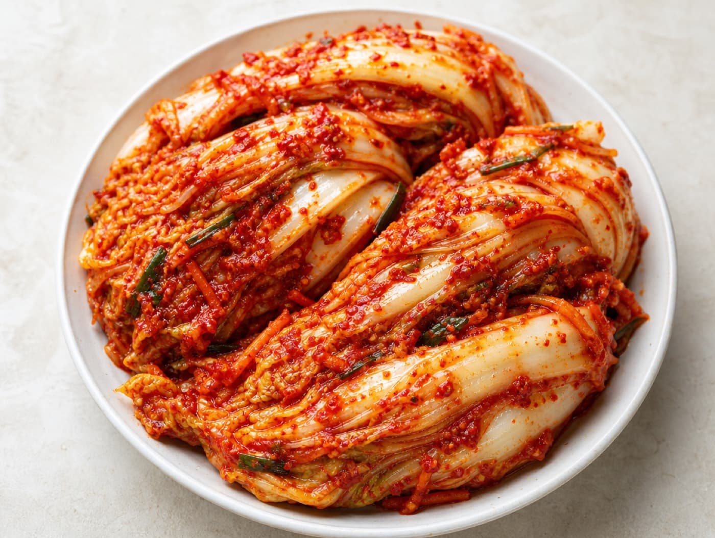 Freshly made baechu kimchi on a white ceramic plate